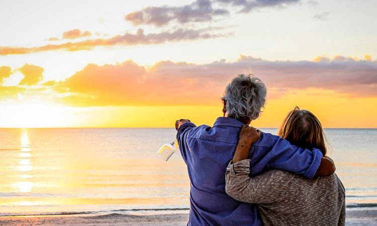 happy retirees enjoying the sunset on the beach in delaware