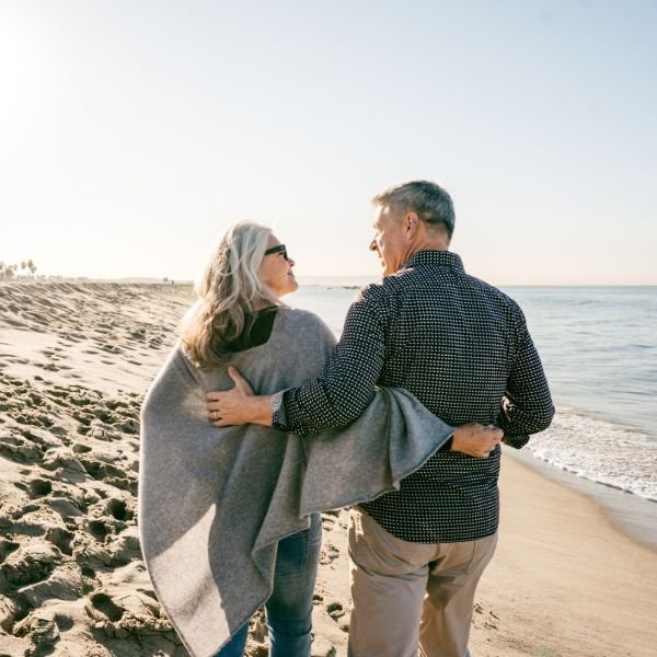 happy retired people walking on the beach